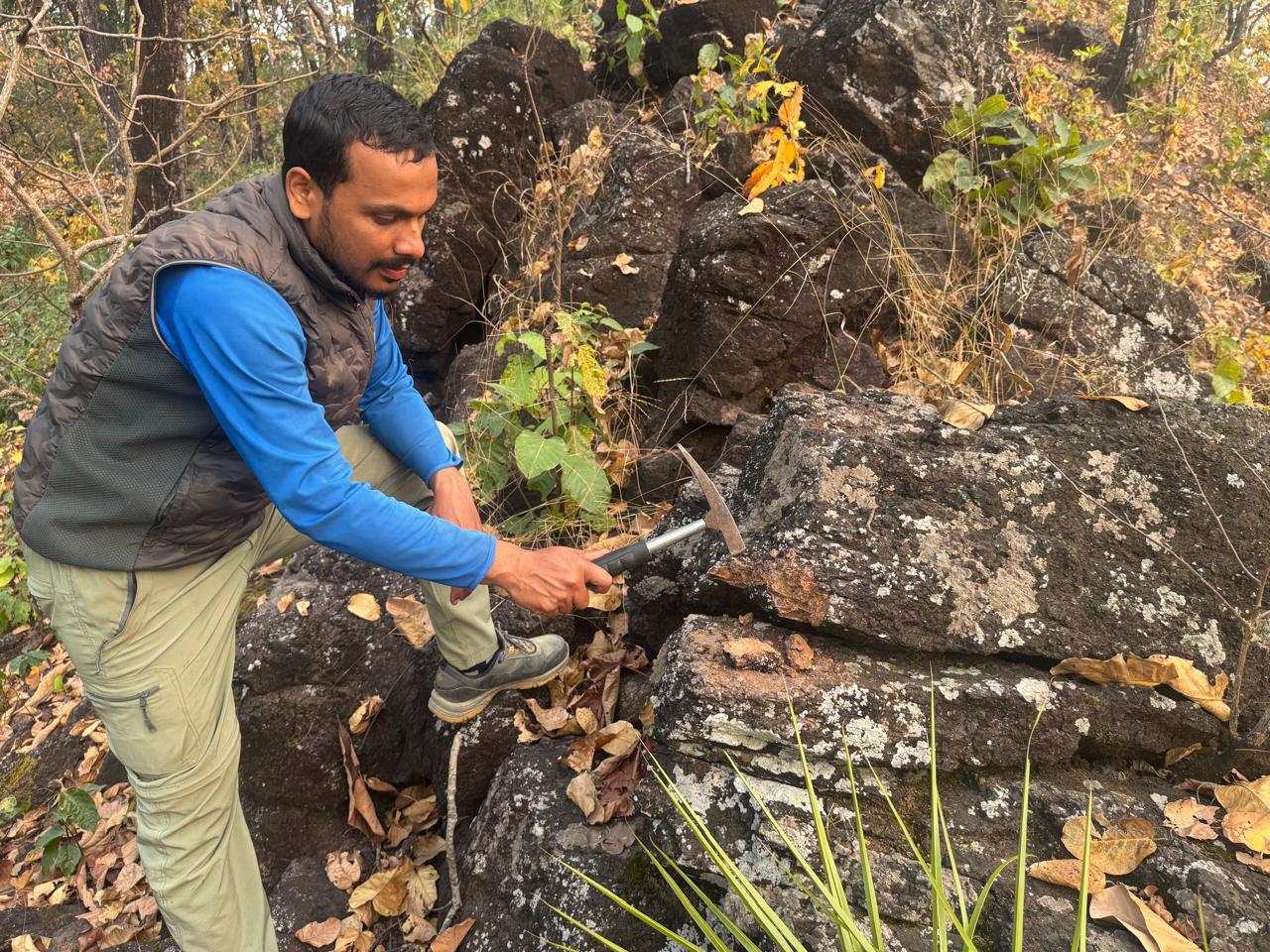 Geologist examining iron prospecting rock sample in Bagmati, Makwanpur
